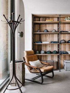 a wooden chair sitting in front of a bookshelf filled with lots of shelves