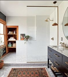 a bathroom with a sink, mirror and bathtub next to a large rug on the floor