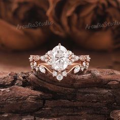 a close up view of a diamond ring on a piece of wood with roses in the background