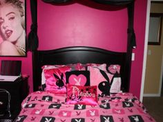 a bed with pink and black decor in a bedroom next to a painting on the wall