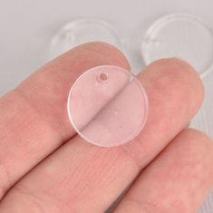 a person's hand holding a clear plastic object in their left hand, with two circles around it