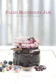 a jar filled with blueberry jam sitting on top of a table