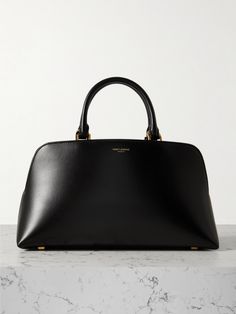 SAINT LAURENT 'Sac de Jour Duffle' tote has been scaled down for days when all you need is the essentials like your phone, keys or a cardholder. Crafted from smooth leather, the bowling-inspired silhouette is stamped with a subtle logo and secures with a gold-tone engraved padlock. Attach the shoulder strap to carry yours cross-body.