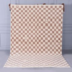 a brown and white checkered blanket hanging on a wall