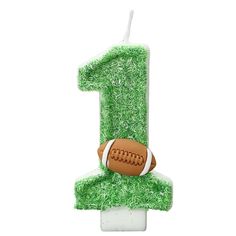 a birthday candle shaped like the number one with a football on it