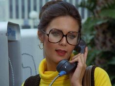 a woman wearing glasses talking on a phone