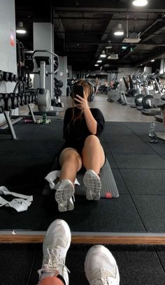 a woman sitting on top of a gym floor