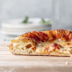 a piece of pizza sitting on top of a wooden table