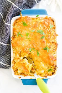 a casserole dish with cheese and parsley on top, ready to be eaten