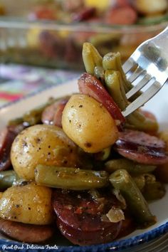 sausage and green bean potato casserole on a plate with a fork in it