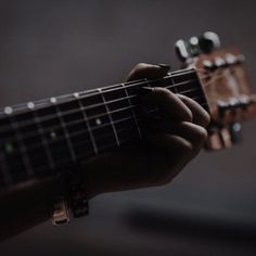 a person holding an acoustic guitar in their hand