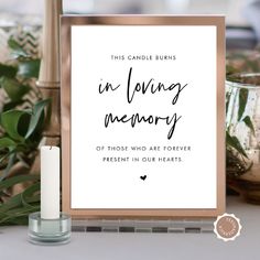 this candle burns in loving memory printable poster is on a table next to candles and potted plants