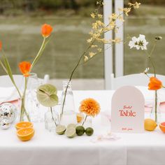 the table is set up with flowers and place cards for guests to sit down at