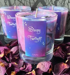 three purple candles with the words sleepy twinklings on them sitting in front of flowers