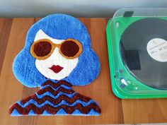 there is a cake that looks like a woman with sunglasses and a record player on the table