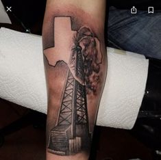 a man's arm with a black and white photo of an oil rig on it