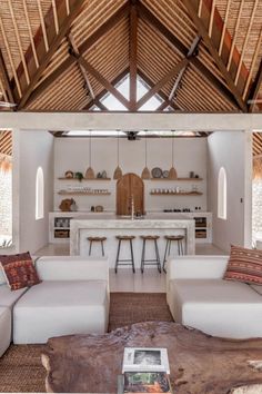 a living room filled with lots of furniture and a wooden roof over it's dining area