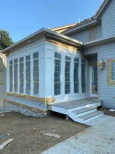 a house that is under construction with some windows on the side and steps leading up to it