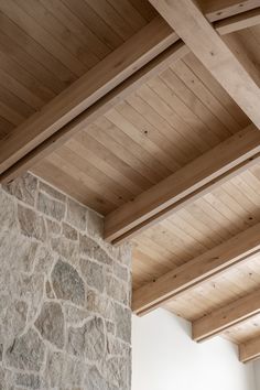 a stone fireplace with wooden beams in a living room