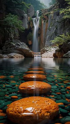 there are many rocks in the water with a waterfall coming out of it's side