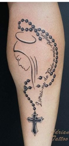 a woman's leg with a rosary and cross tattoo on the side of it