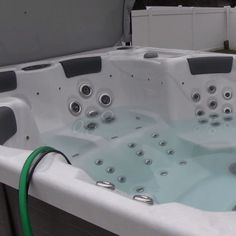 an outdoor hot tub with multiple jets and hoses attached to the side of it