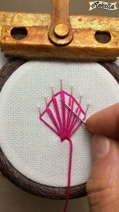 someone is stitching on the side of a small piece of fabric with a needle