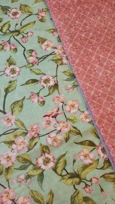 two quilted bedspreads with pink and green flowers on them, next to each other