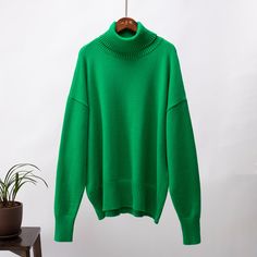 a green turtle neck sweater with the word zevity written on it in black