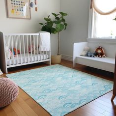 a baby's room with a white crib and blue rug