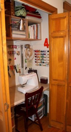 a sewing machine sitting on top of a table next to a wooden cabinet filled with lots of crafting supplies