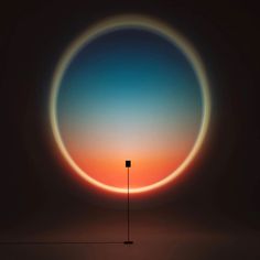 an orange and blue circle with a light pole in the middle, against a dark background