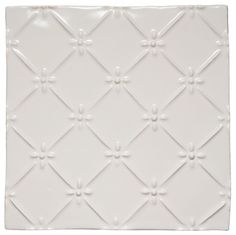 a white square tile with an intricate design