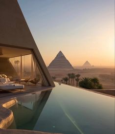 an outdoor swimming pool with the pyramids in the background at sunset or sunrise time