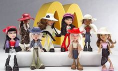 a group of dolls that are standing in front of a mcdonald's sign with hats on