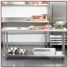 a stainless steel table with bowls and pans on it