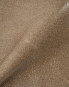 a close up view of a brown leather textured material that is very soft and shiny