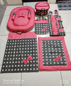 a pink and black baby set is laying on the floor next to it's accessories