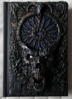 a black book with an evil face on it's cover and the words demon written in