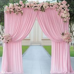 an outdoor ceremony with pink drapes and flowers