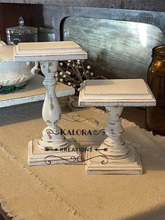 two white pedestals sitting on top of a table