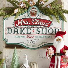 a sign that says mrs claus'bake shop with santa clause holding a cookie