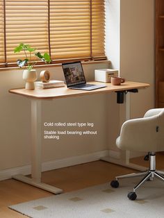 a laptop computer sitting on top of a wooden desk next to a window with blinds