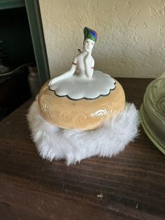 a ceramic figurine sitting on top of a wooden table