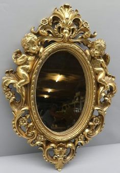 an ornate gold framed mirror on a wall