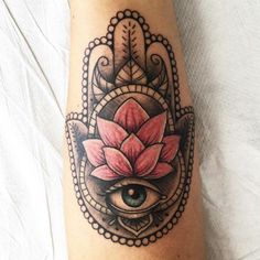 a hamsa tattoo with an eye and flower on it