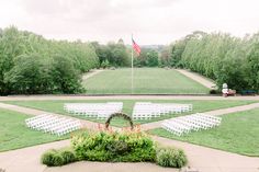 an outdoor ceremony with rows of white chairs and american flag in the backgroun