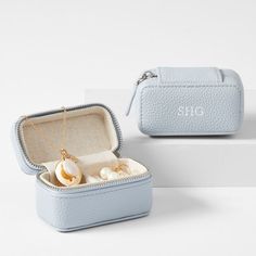 two jewelry cases with pearls in them sitting next to each other on a white surface