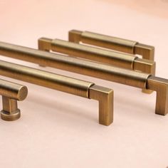 four brass colored handles on a white surface