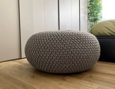 a crocheted ottoman sitting on top of a hard wood floor